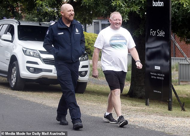 A smiling Mick Murphy is pictured with police last Friday, the day after his wife Samantha's dog Ruby went missing.
