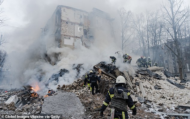 Rescuers conduct a search and rescue operation amid a collapsed wall of a residential building after the Russian missile attack on January 23, 2024 in Kharkiv, Ukraine.