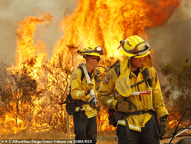 Cal Fire firefighters protect a structure near Montiel Truck Trail during the Valley Fire in San Diego County.