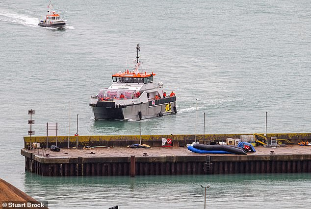 The Border Force vessel Typhoon carrying migrants arrives at Dover docks on Saturday. One image showed a migrant wrapped in an aluminum blanket being pushed in a wheelchair.