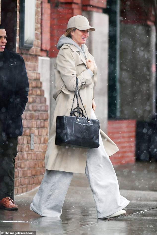 The supermodel, 43, wore a gray hoodie with matching sweatpants and a cream duster on top.
