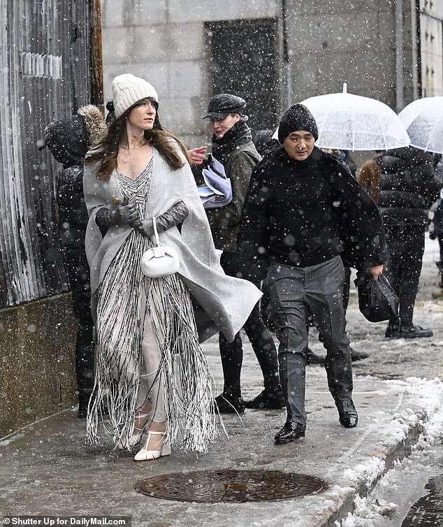 One attendee wore a fringed dress with a gray sweater and beanie as she walked through the sleet.