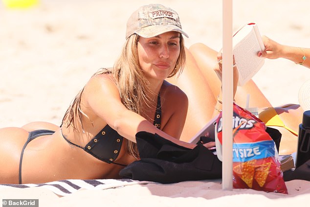 During their day at the beach, the two blondes enjoyed some cheese Doritos.