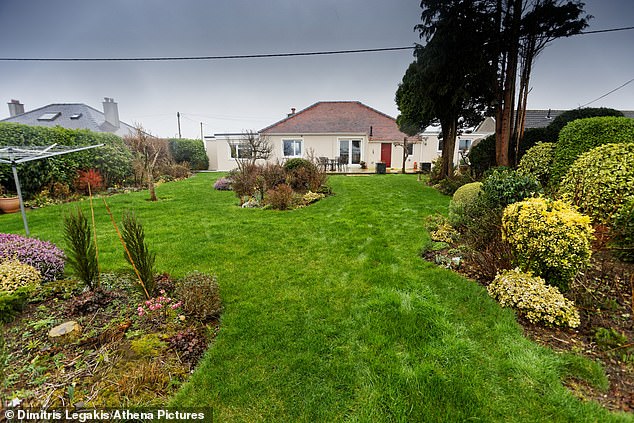 Workload: The Steeles, who live on the outskirts of Haverfordwest in Pembrokeshire, are looking to downsize to a property with a more manageable garden than their current home (pictured).