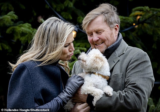 Queen Maxima fawned over her dog while being held by King Willem-Alexander