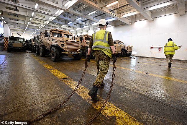 Military vehicles are loaded onto the Anvil Point ship at Sea Mounting Center, Feb. 13, 2024, in Marchwood.