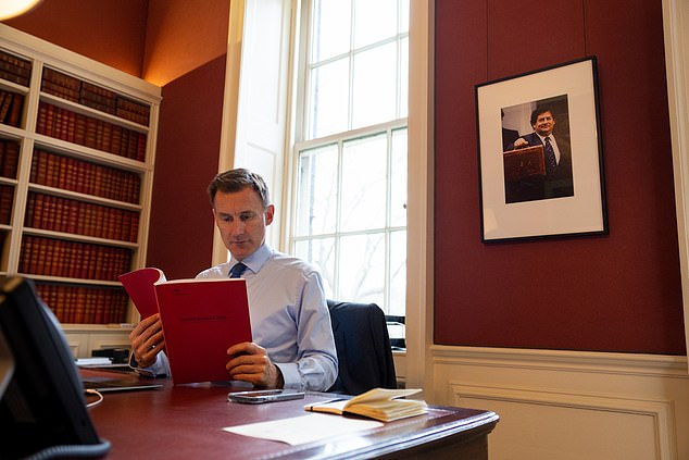 Chancellor Jeremy Hunt pictured last night preparing for his spring budget