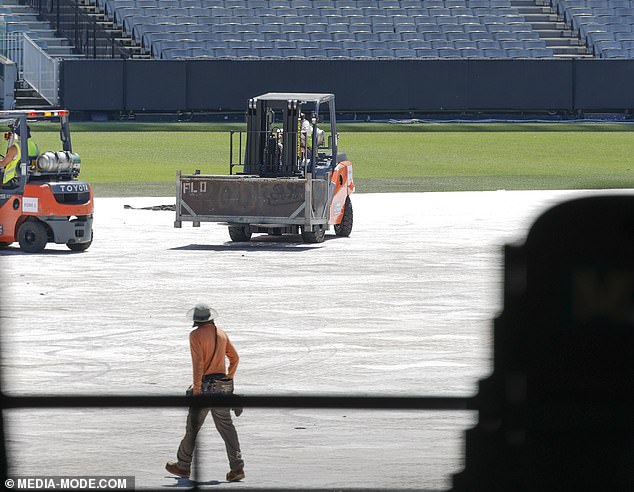 Forklifts transported large structures across the field, while huge lighting stands were lifted into place.