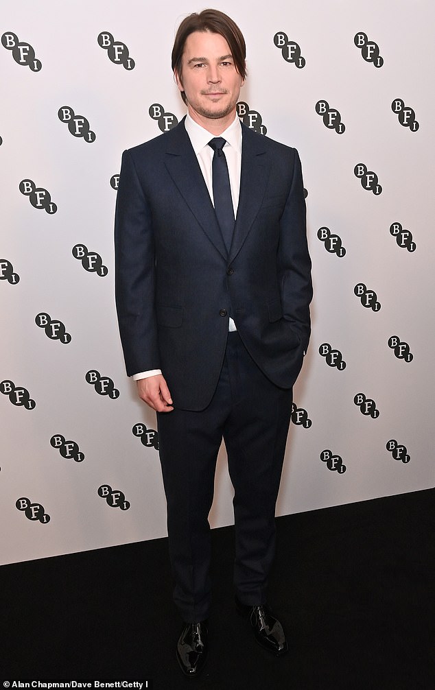 Josh Harnett wore a black suit with a matching tie and white shirt.