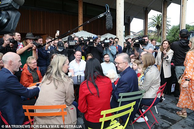 Anthony Albanese sitting around a cafe table drinking coffee with friends and followers