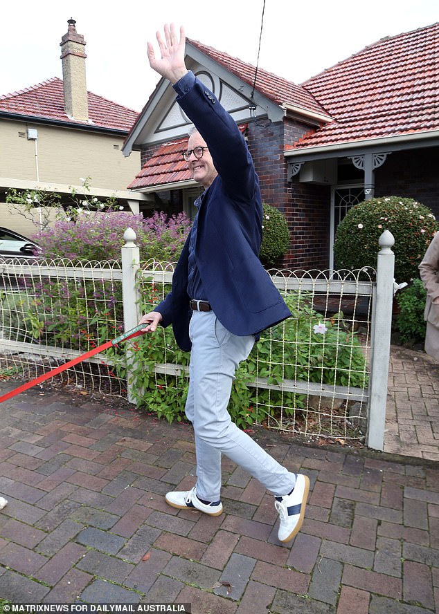 Albanese waves to journalists and locals as he takes his morning walk in Marrickville.