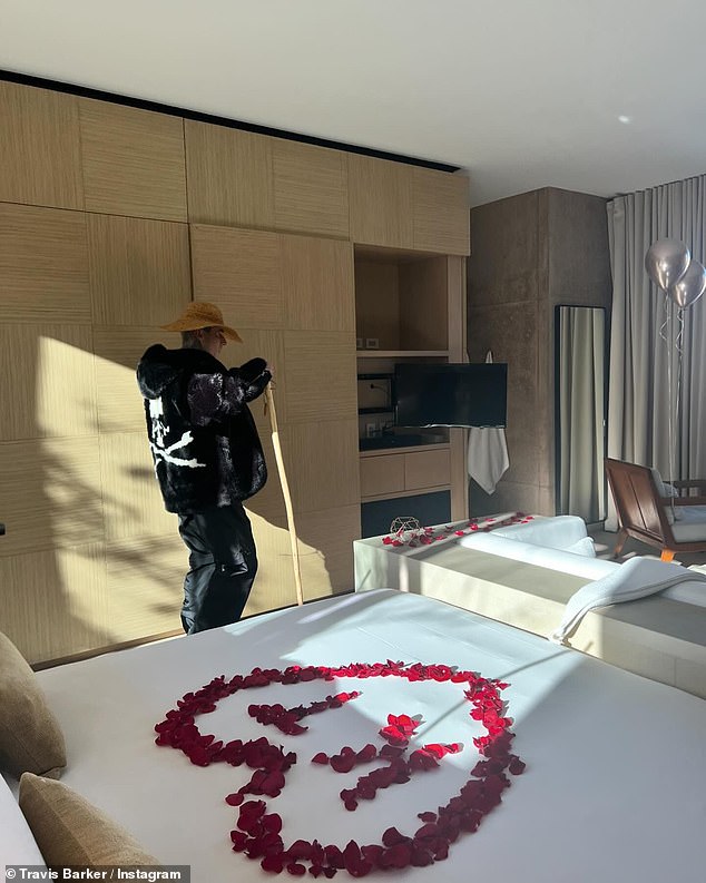 In another photo, Travis is seen preparing his bedroom for Valentine's Day, while scattering red rose petals on the bed that spell out the initials of his name in the middle of a large heart.