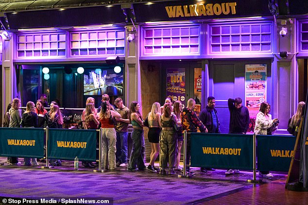Partygoers queue outside a club in Birmingham