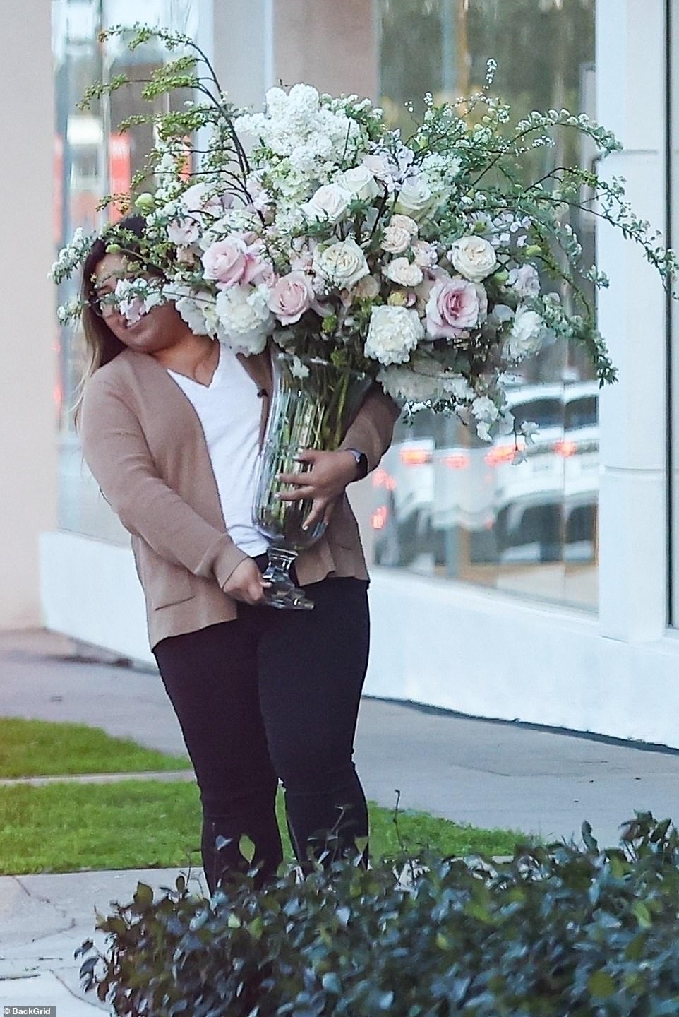Behind jewelry designer De Ramon was an assistant who could barely bear to carry a large bouquet of roses in a glass vase on legs.  It looked like Ines was taking home the big Valentine's bouquet that the Troy actor probably sent to her office the day before.