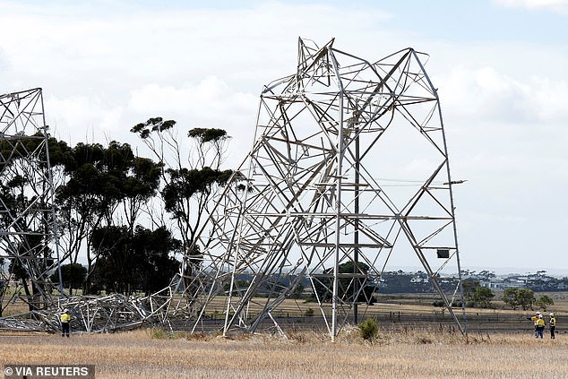 Workers are seen inspecting a damaged transmission tower at Anakie in Victoria on Tuesday.