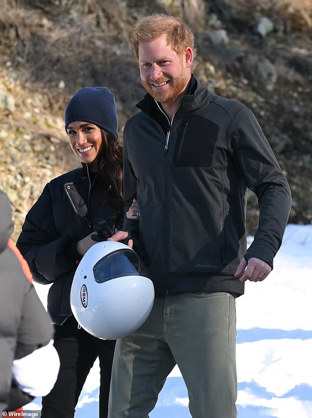Meghan held Harry's arm as the couple walked through the snowy resort.