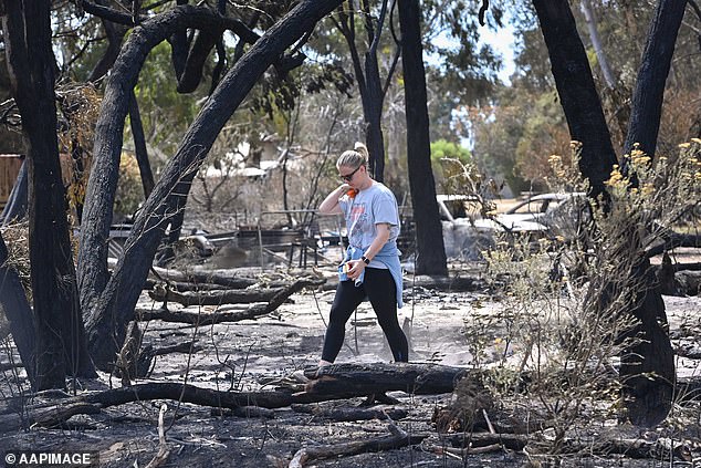 A woman walks through the charred remains of the bushfires in the western Victorian town of Pomonal.