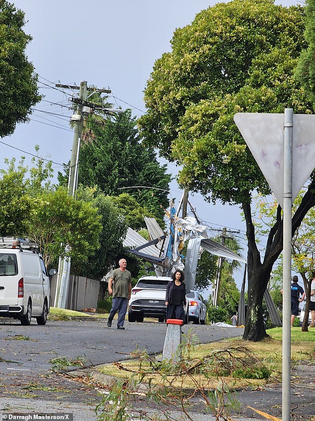 Locals assess some of the damage left by strong storms in the Mount Waverley area of ​​Victoria.