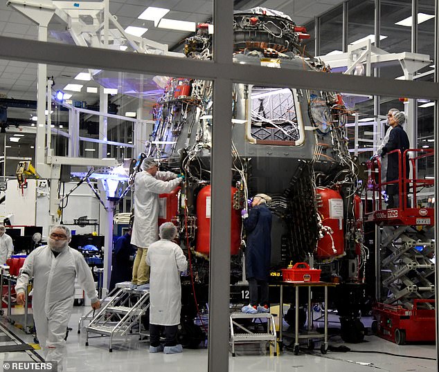 SpaceX technicians work on the Crew Dragon Demo-2 spacecraft at SpaceX headquarters in Hawthorne, California. There is virtually nothing painted in 'warning yellow' in sight, due to Musk's distaste for the color for reasons of personal style.