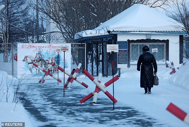 A woman walks toward the entrance to the IK-3 prison colony, where Russian opposition politician Alexei Navalny died while serving his sentence.  The prison is located in the Kharp settlement in the Yamal-Nenets region.