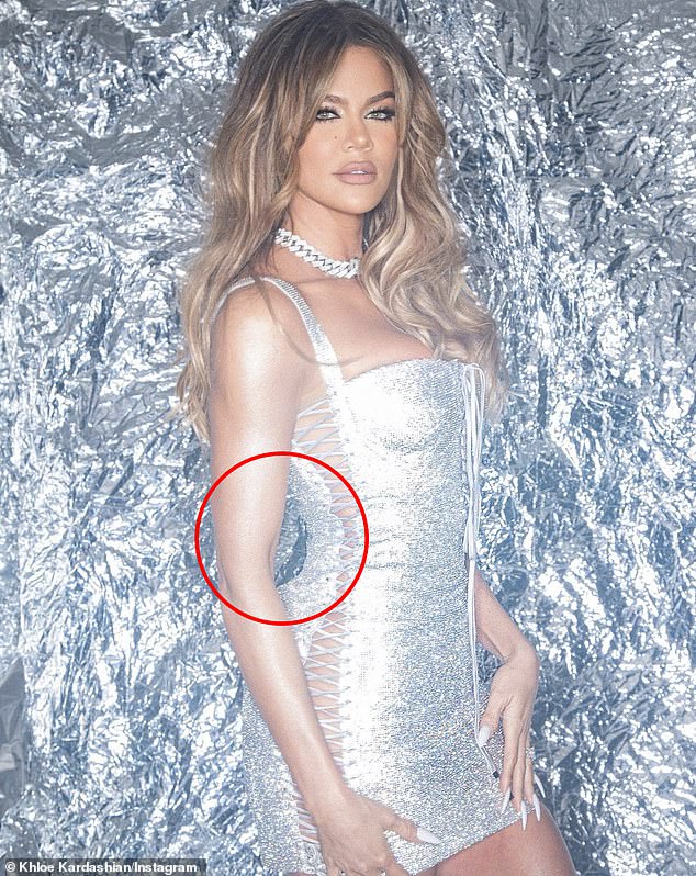 Another photo shows the reality star's waist drawn in with a disproportionate butt. Khloe was posing in front of an aluminum backdrop, which was noticeably warped as she attempted to shrink her midriff.