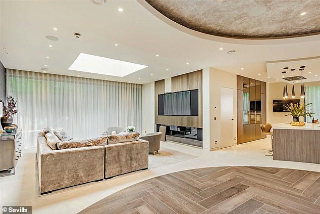 The center of the underground living space has a modern herringbone-shaped wooden floor.