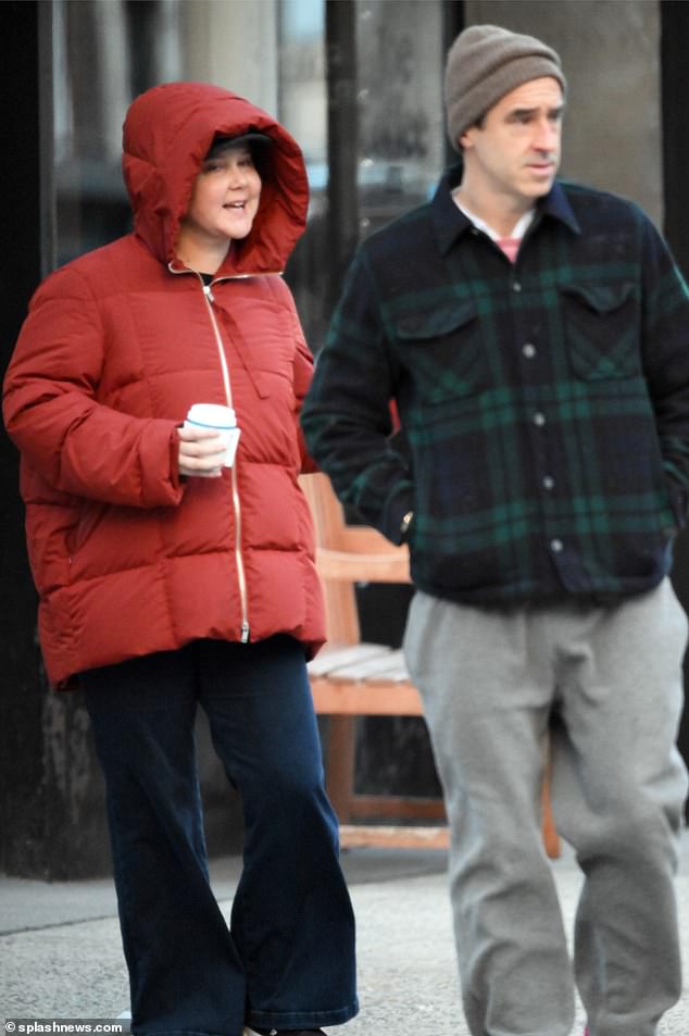 Schumer held a hot drink in her hand as her husband strolled alongside her, who also opted for comfort.