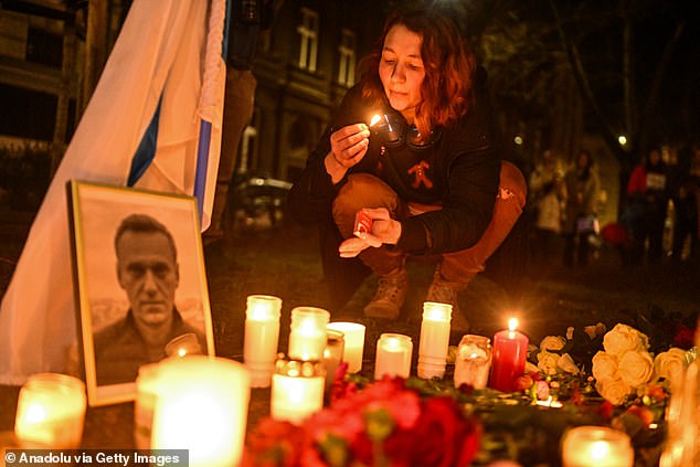 Supporters of the late Russian opposition leader hold banners and place candles around a makeshift memorial in Krakow, Poland.