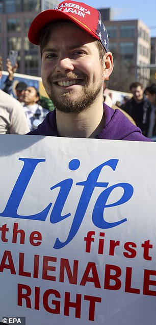 A man holds a sign during a pro-life demonstration.