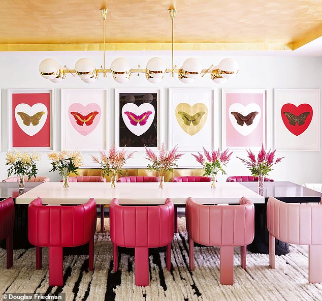 The dining room has custom-stained chairs in shades that match the pink lipsticks from Jenner's makeup collection.  Damien Hirst's artwork fills the walls.  Find a variety of large pendant lamps at roche-bobois.com