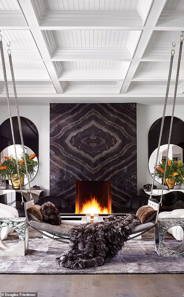 The family room stands out for the fireplace surround covered in black marble.  Ralph Pucci's custom swing sofa is the center seat, flanked by Kelly Wearstler marble tables.