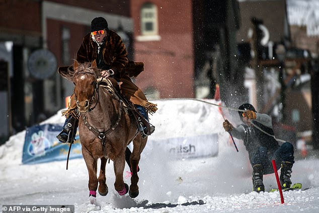 A rider races down Harrison Avenue while pulling a skier during the 75th annual Leadville Ski Joring Weekend Competition on March 5, 2023 in Leadville, Colorado.