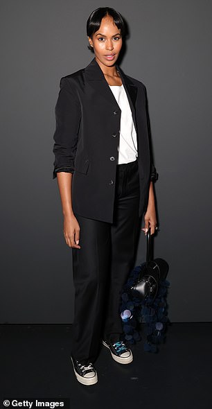 The model wore an elegant black blazer, which she rolled up, over a white T-shirt with a slight V-neckline tucked in.
