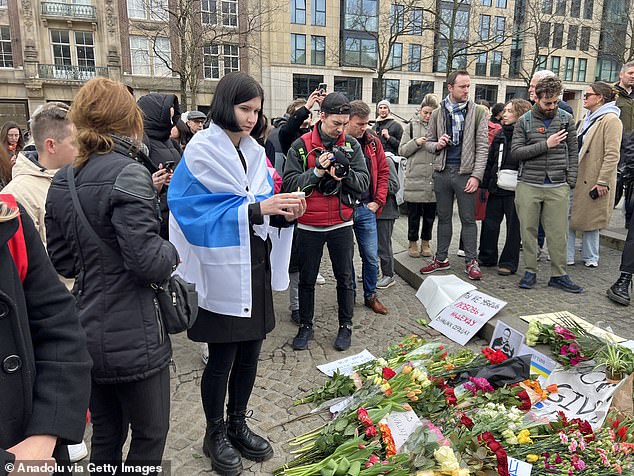 People leave flowers and candles as they gather for a demonstration in Amsterdam.