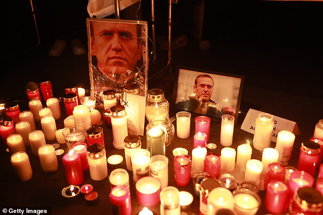 People light candles during a vigil for the critic in Germany