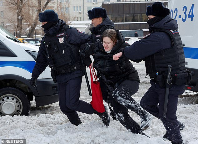 Police officers detain a woman during a rally in memory of Russian opposition leader Alexei Navalny near the Wall of Pain monument