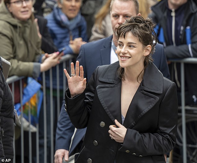Kristen dressed in a black coat for her arrival at the festival, where she was mobbed by fans.
