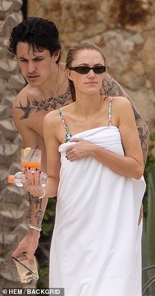 Dalton was shirtless, showing off his many tattoos, and carried a drink as he walked the deck alongside his lady love.