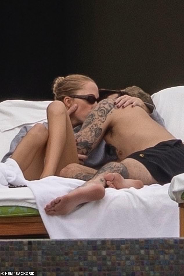 The couple were seen kissing while lounging in the sun together.