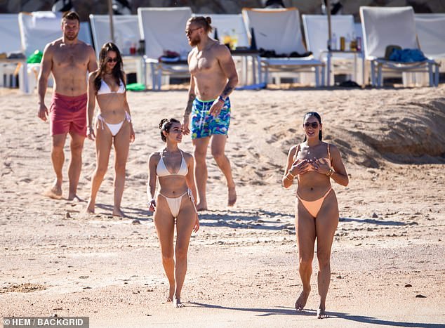 The three couples take a walk on the beach in Mexico: Kittle was accompanied by his wife Claire (right).