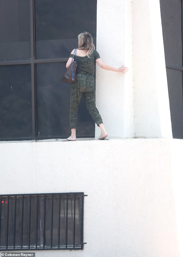 The Melrose Place alum opted to keep her fiancé Chris Heisser waiting in her car and was seen swinging on the edge of the building last year.