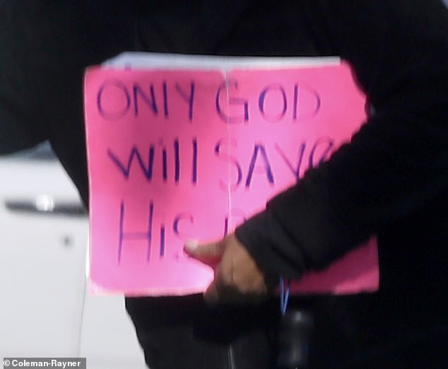 The beggar was carrying a large pink neon sign that said 