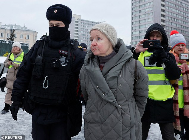 Police detain a woman during a rally in memory of Russian opposition leader Alexei Navalny near the Mourning Wall, a monument to victims of political repression in Moscow.
