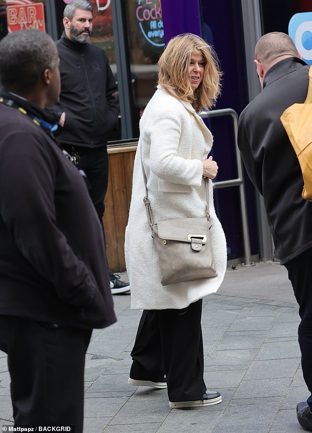 Kate put on a stylish show in a cream-coloured jumper and matching chic coat, paired with black trousers and trendy trainers.