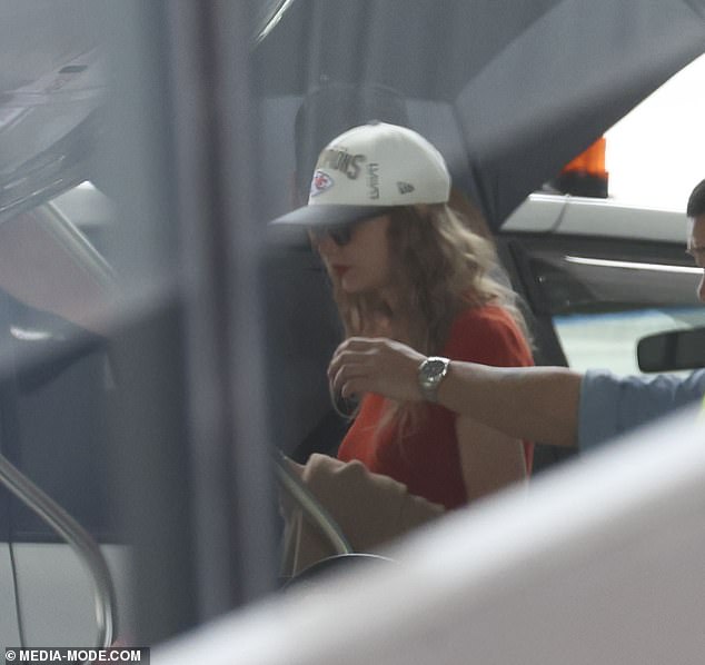 The singer was seen boarding her private jet in Melbourne later that day wearing a Kansas City Chiefs Super Bowl LVIII Champs baseball cap in tribute to her boyfriend Travis Kelce (pictured).
