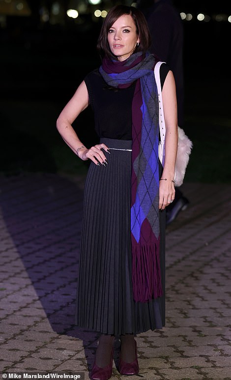 Lily Allen, 38, was the epitome of elegance as she arrived in a figure-hugging black top which she paired with a long gray pleated skirt.