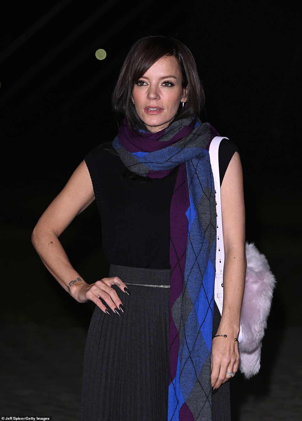 She wrapped a long argyle scarf around her neck that featured the color blue and purple, which matched her heels.