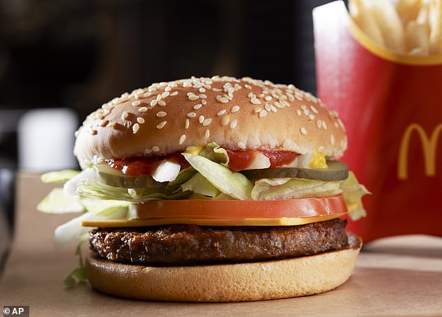 A photo of Mickey D's burger loaded with toppings and a sesame bun.