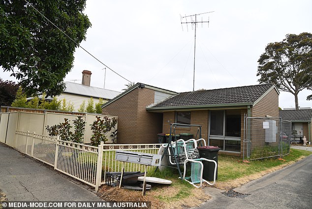 A woman believed to have been living with her brother's body is understood to have cut the front lawn of her property (pictured) with scissors.