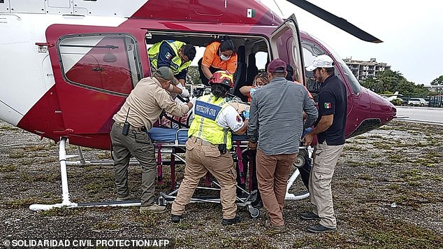 Paramedics lift one of the victims of the accident between two vehicles that left six dead, including five Argentine tourists, on the Playa del Carmen-Tulum highway on Sunday.